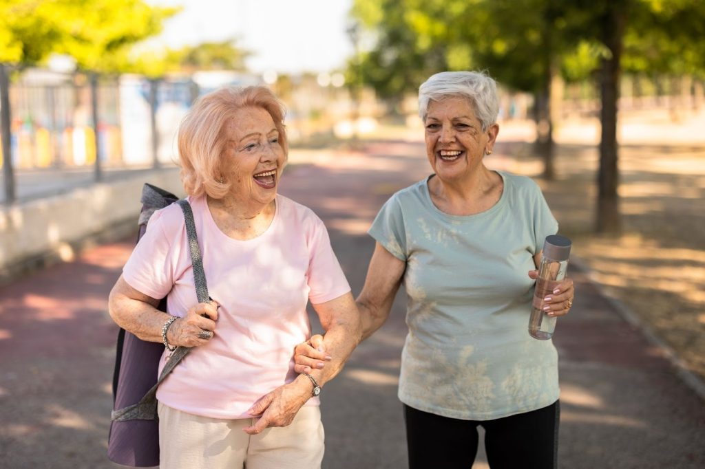 Two senior women enjoying a walk together. They are able to stay active and maintain their hobbies at an Independent Living Community. 