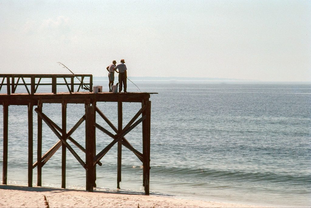 Two retirees fishing off a pier in Gulf Shores.