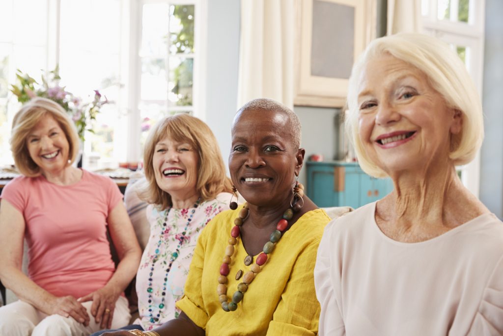 A group of senior women spending time together in a shared space at an independent living community.