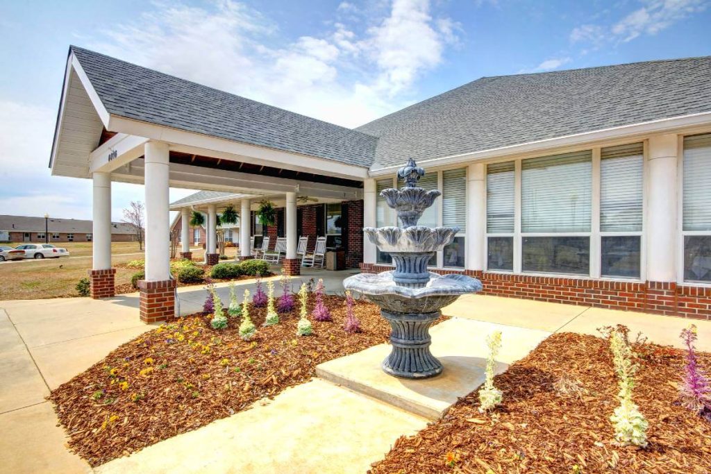 The front exterior of The Madison Village, complete with stunning landscaping and a water fountain.