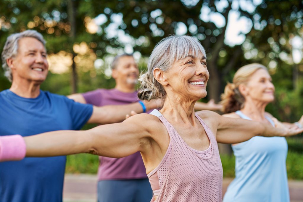 Four active seniors stretch in the Alabama sunshine during their weekly fitness class.